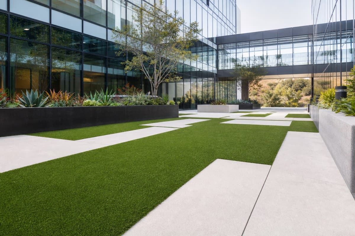 Commercial property courtyard with artificial turf between concrete pavers